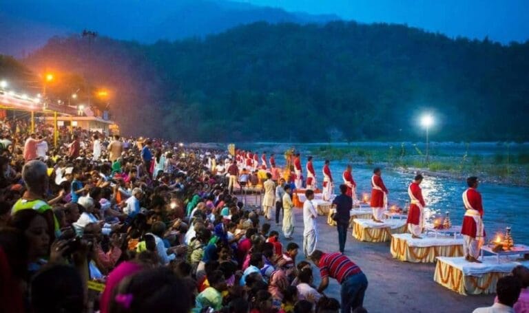 Evening Ganga Aarti at Triveni Ghat in Rishikesh with priests performing rituals beside the River Ganga.