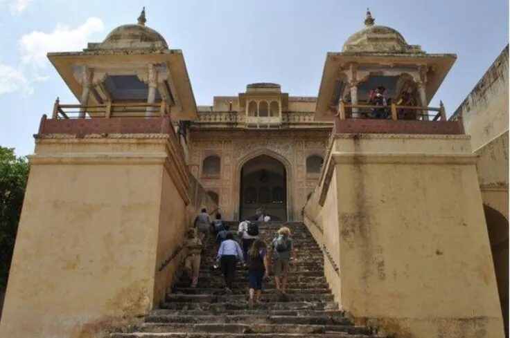 Visitors walking up the stone steps leading to the grand entrance of Amer Fort in Jaipur, India.