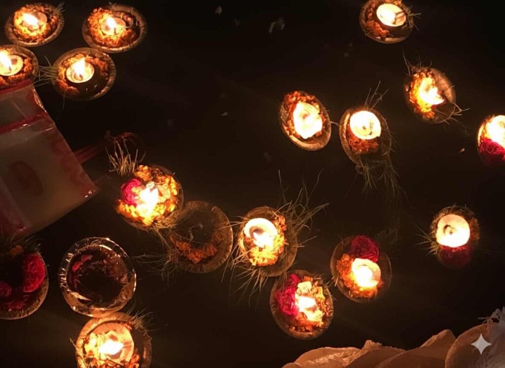 Floating diyas with flowers drifting on the River Ganga at night after the Ganga Aarti in Haridwar.