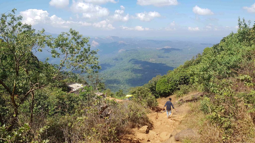 Descending back toward the temple area on the Kudajadri trail with valley views ahead