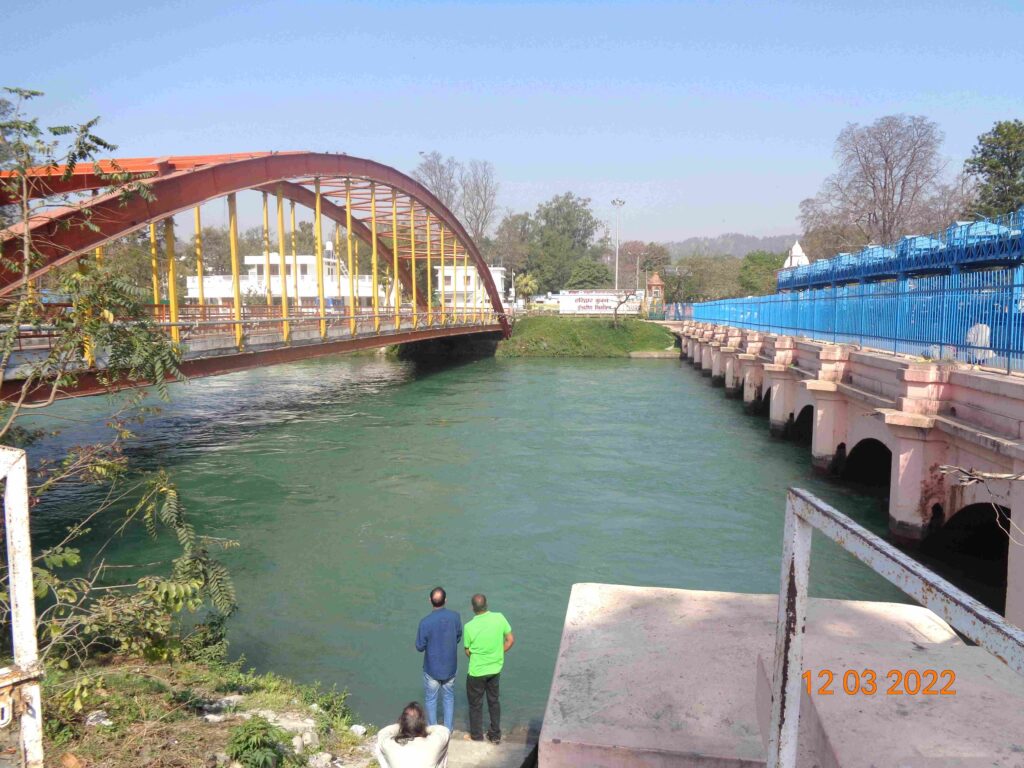Haridwar — standing by the iconic bridge near Har Ki Pauri, where the sacred Ganga begins her plains journey