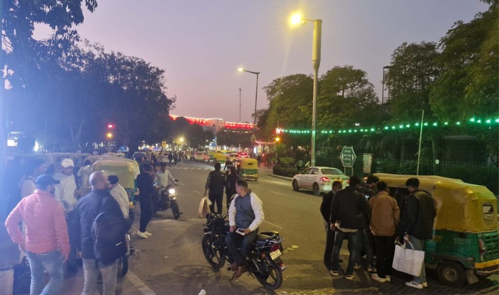 Evening street life in New Delhi with autos bikes and pedestrians