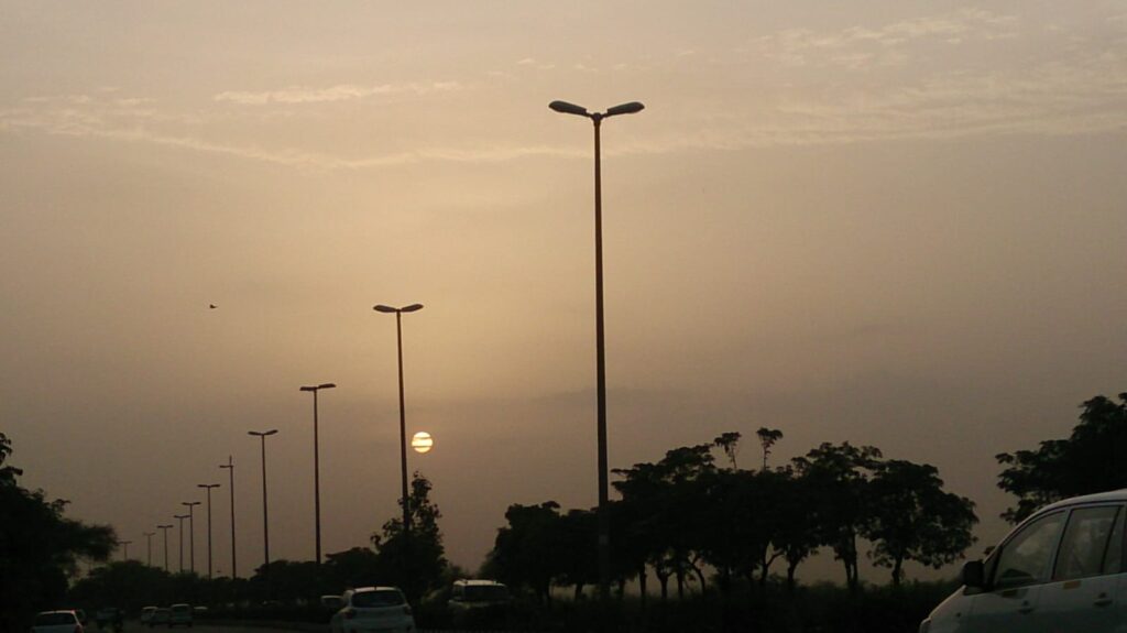 Evening sunset over highway with trees and streetlights in Delhi