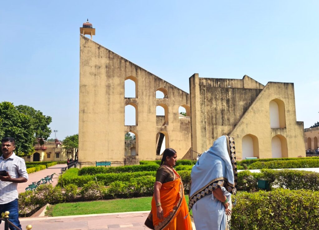 Samrat Yantra at Jantar Mantar Jaipur showing massive triangular sundial with arched walls and visitors in foreground