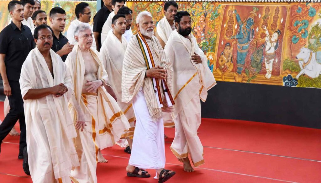 Prime Minister Narendra Modi walking inside Guruvayur Temple premises wearing traditional Kerala temple attire including mundu and shawl during a ceremonial visit.